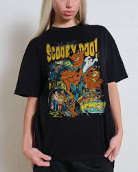 A girl holding her graphic T-shirt away from her body. On the shirt is a vintage Scooby doo design.