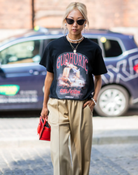 A pretty lady wearing a graphic tee with nice pants to create a beautiful outfit.