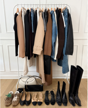 Lots of jackets, T-shirts and plants on a rack. with 5 pairs of shoes below it.